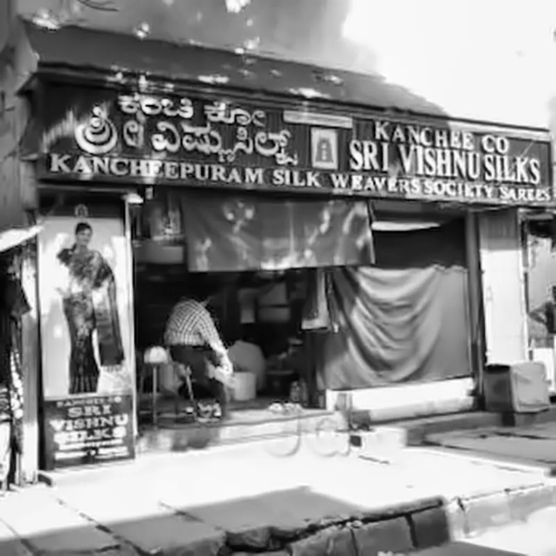 Black and white archival photograph of the original Sri Vishnu Silks storefront, Kancheepuram Silk Weavers Society Sarees