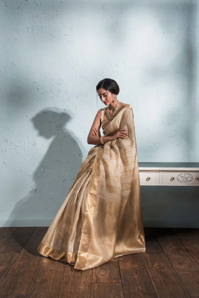 Model draped in a gold zari-bordered designer saree